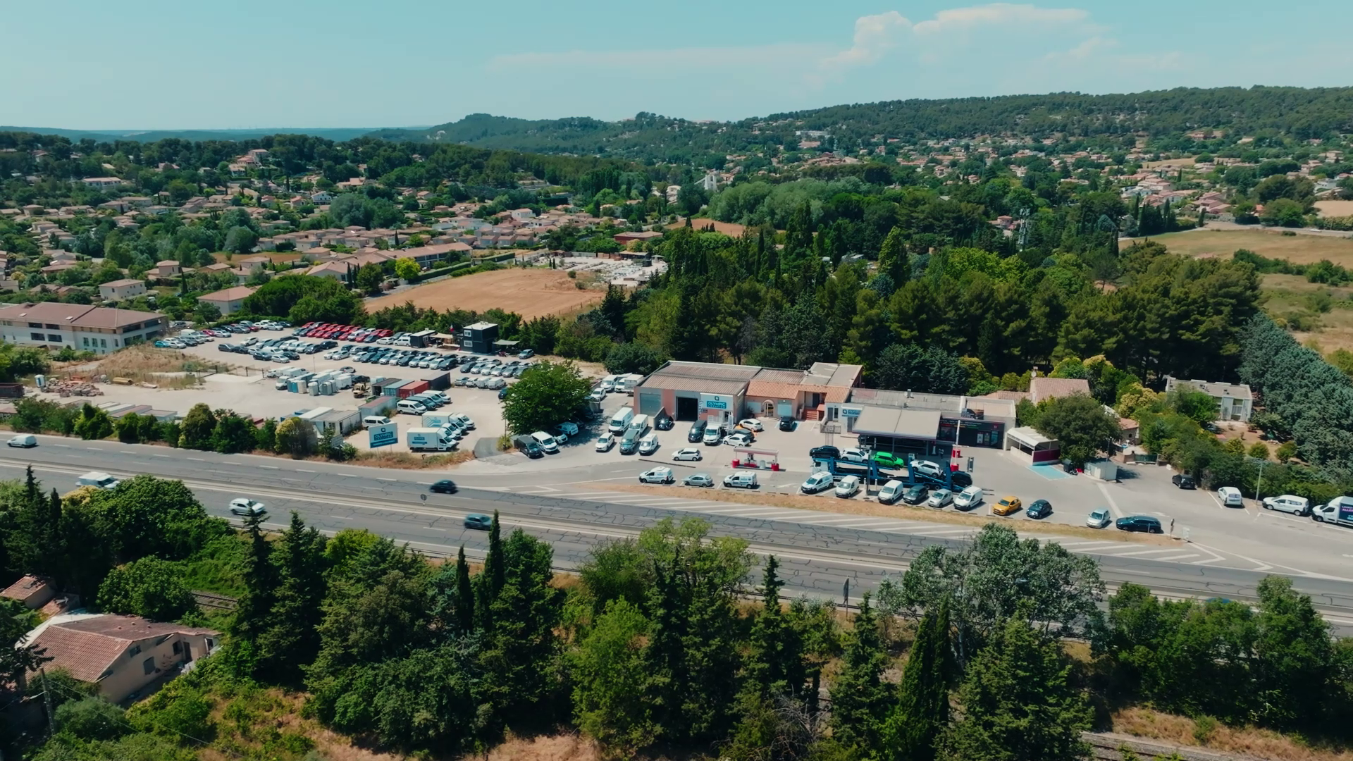 Vue aérienne large d'un site automobile en bord d'axe