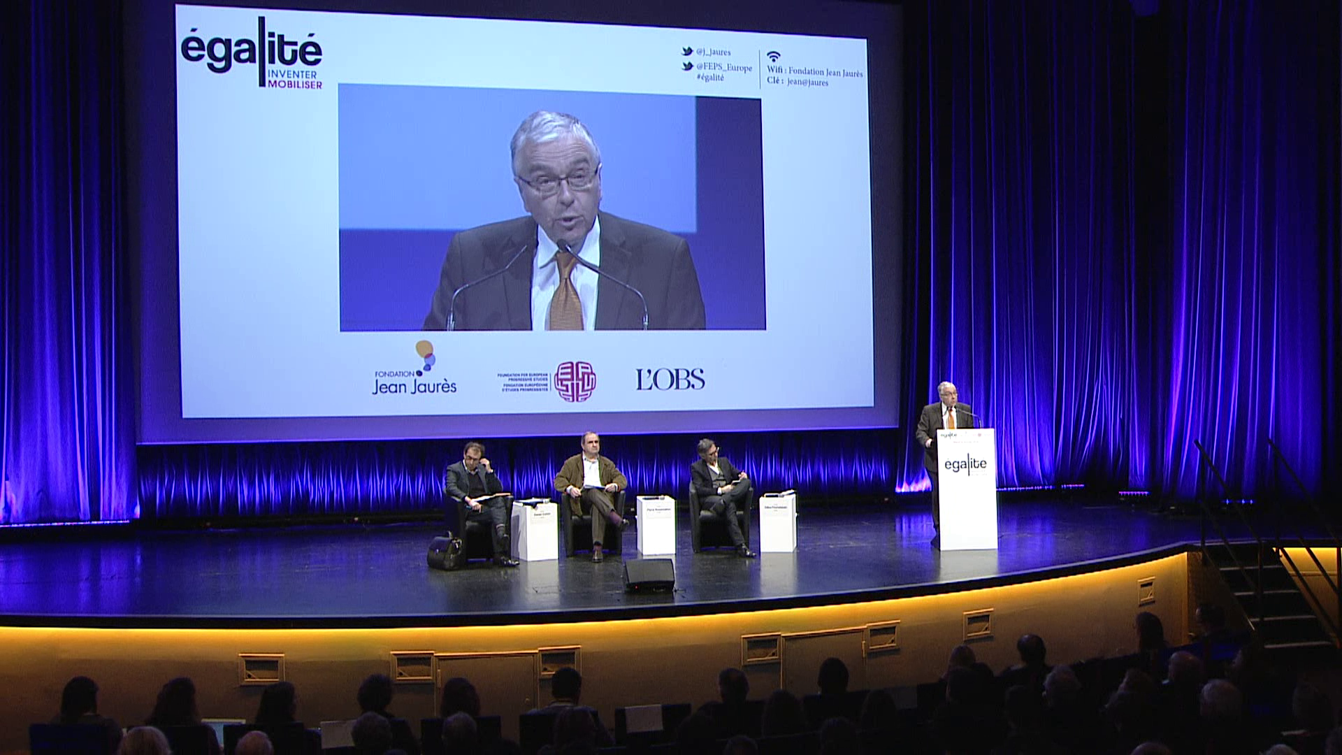 Diffusion en direct d'un congrès devant un public nombreux agitant des drapeaux