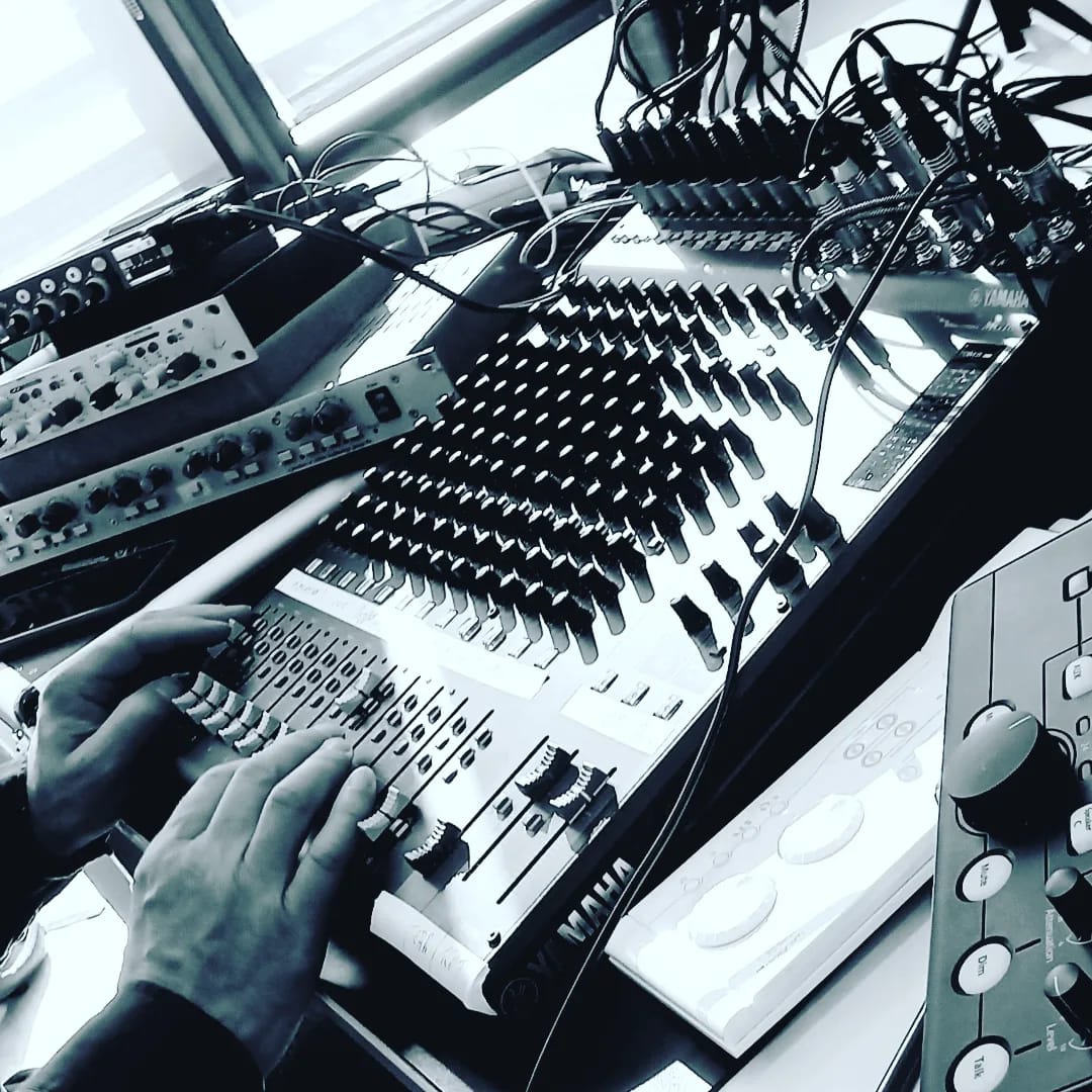 Mains d'un ingénieur du son sur une console de mixage Yamaha en régie